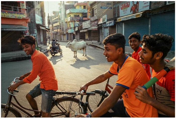 Group of young boys riding bicycles and smiling on a street in Asia capturing raw and captivating street moments