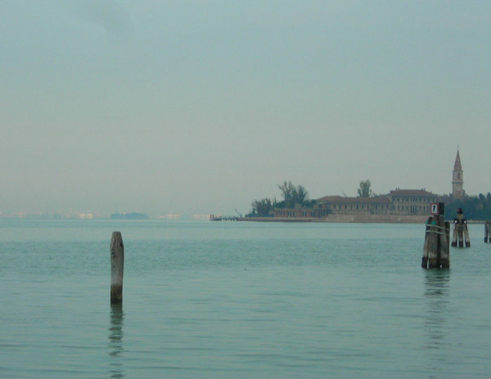 Foggy view of a deserted eerie island surrounded by still water, representing one of the scariest places around the world.