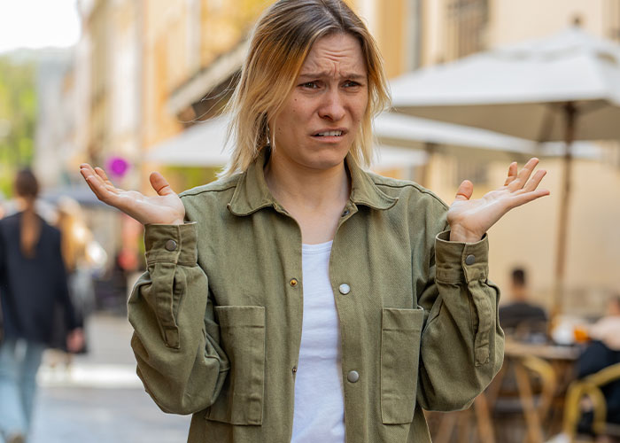 Woman outdoors looking confused and frustrated reacting to unhinged things men have said about her looks in public.