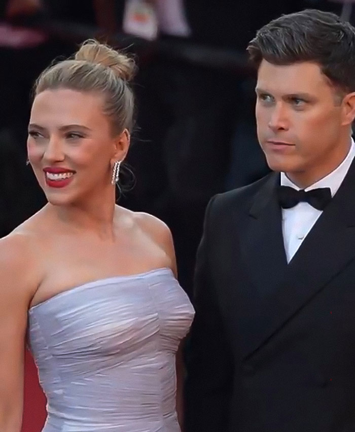 Scarlett Johansson wearing elegant dress with costar in tuxedo at premiere, stunning fans with unexpected kiss on lips.
