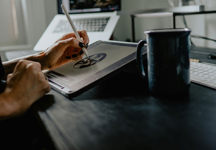 Person using a stylus on a digital tablet, illustrating creativity and work related to millennials' biggest lies growing up.