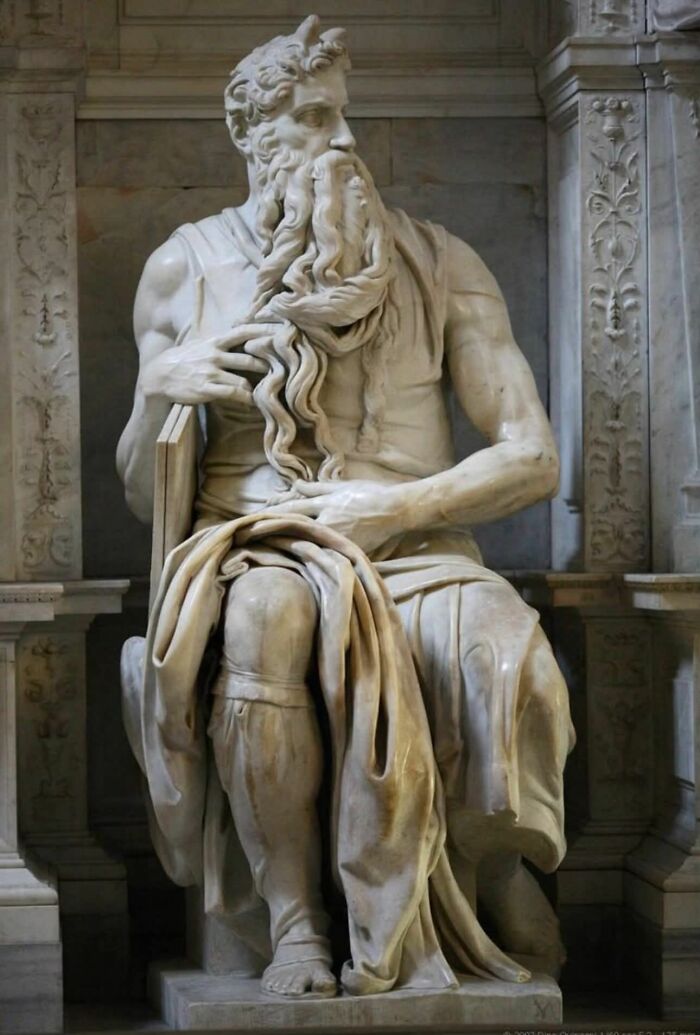 Marble sculpture of a seated bearded man with detailed drapery, showcasing craftsmanship in the archaeology world.