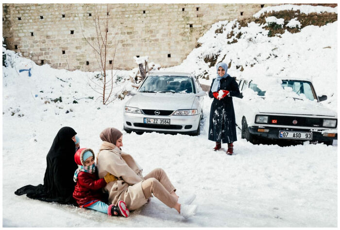 Family enjoying snowy street scene in Asia, capturing raw and captivating moments through the lens of a vagabond photographer.