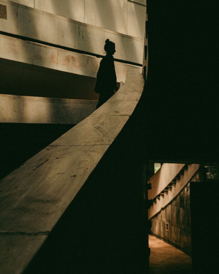 Silhouette of a person on urban staircase with moody lighting, captured by a Helsinki-based photographer in real street moments.