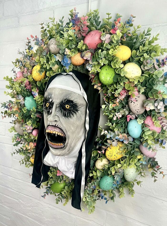 Creepy nun face wreath with colorful Easter eggs and greenery in a bizarre DIY craft project fail.