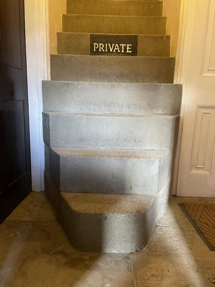 Narrow concrete death stairs with irregular steps and a private sign creating a hazardous climbing option indoors.