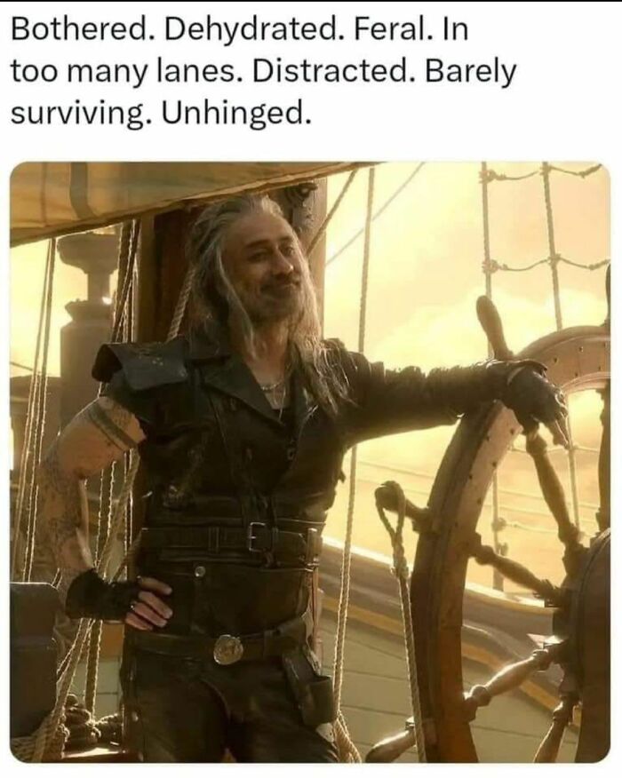 Man with long hair and leather outfit standing by ship's wheel looking distracted and unhinged, relatable meme.