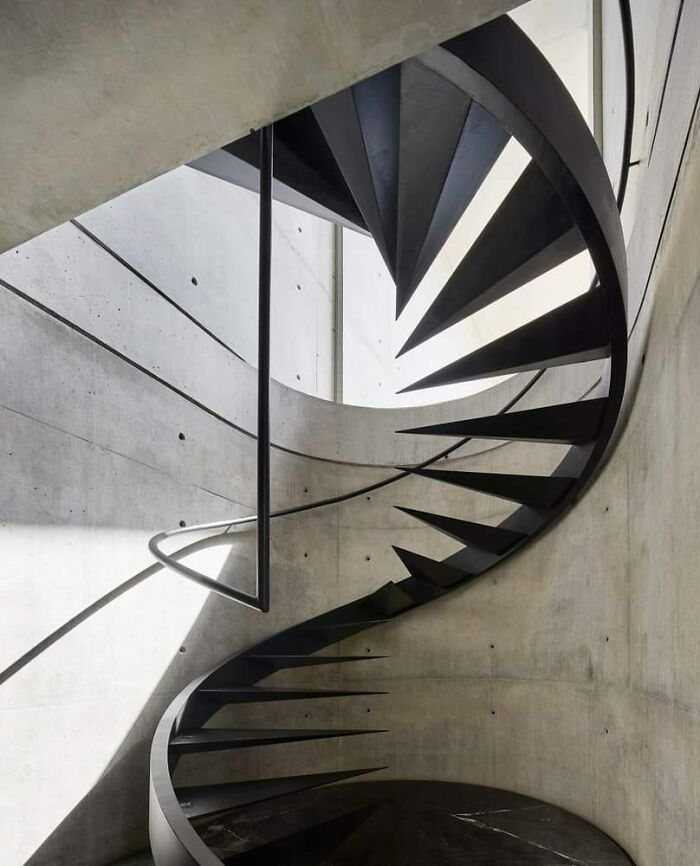 Spiral death stairs with sharp, angular steps in a concrete stairwell, creating an intimidating and dangerous look.