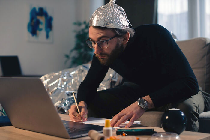 Man wearing a tin foil hat while working on a laptop, symbolizing a good trend slowly disappeared in online discussions.