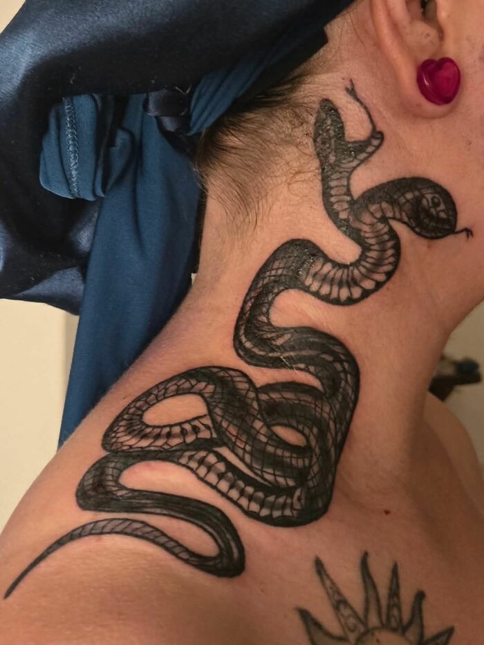 Snake tattoo on neck showcasing a hilariously bad tattoo example of inkshaming from a funny tattoo collection.