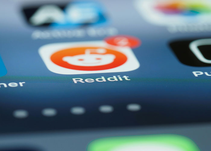 Close-up of a smartphone screen showing the Reddit app icon, related to stories about called off engagements.