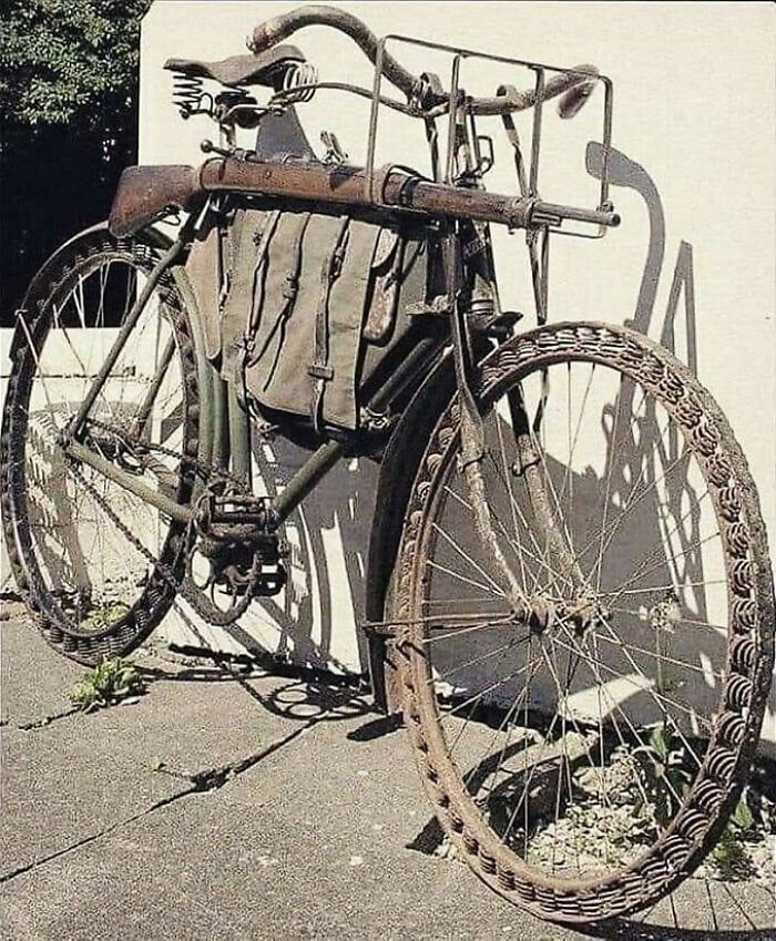 Old rusted military bicycle with a rifle attached and leather bags, showcasing archaeology world historical relics.