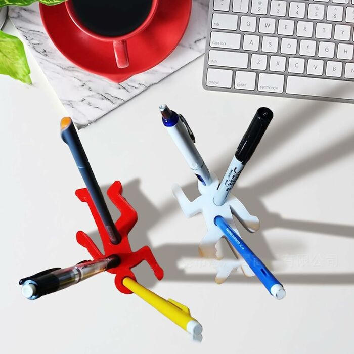 Colorful pen holders on a desk with pens, a keyboard, and a coffee cup, adding fun to your desk essentials.