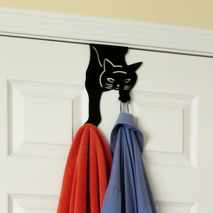 Black cat-shaped over-the-door hook holding two towels, a creative product featured as a star performer in halftime show.