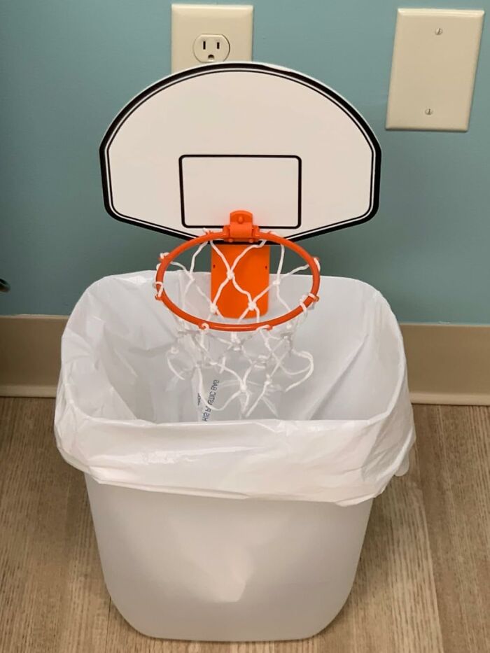 Mini basketball hoop attached to trash can, a fun desk accessory to make the 9-to-5 less blah and boost office enjoyment.