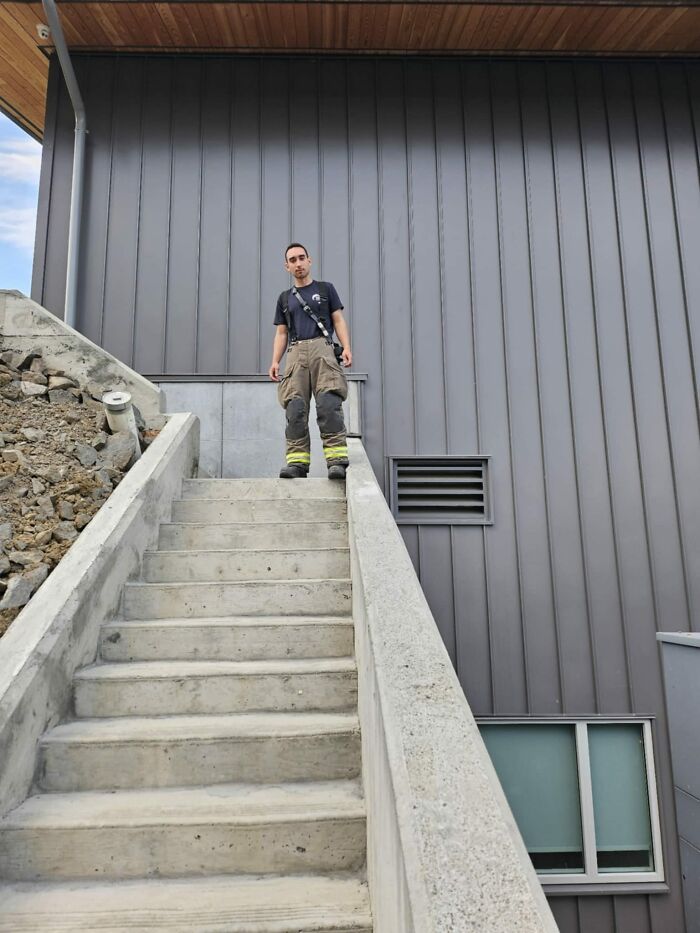 Man standing at the top of a concrete staircase with a steep drop, illustrating a dangerous death stairs scenario.