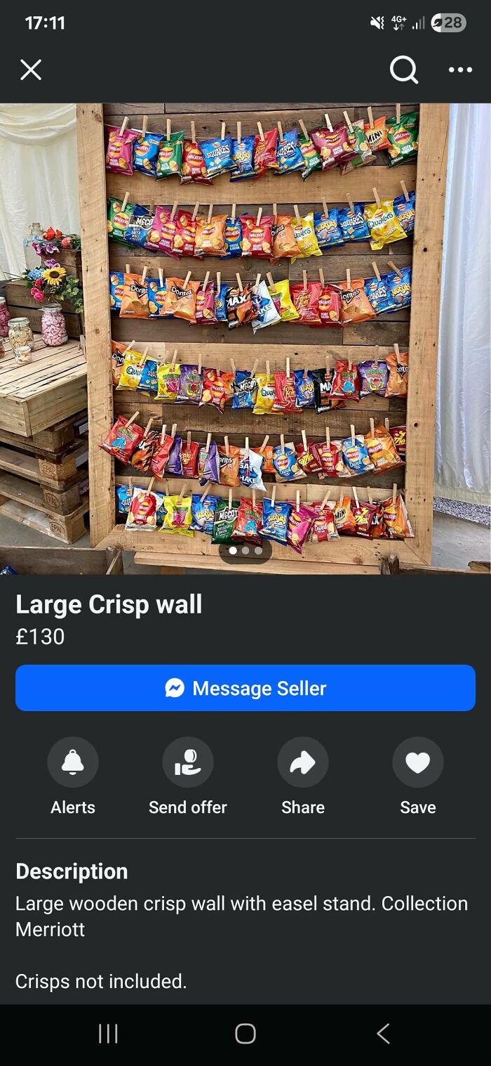 Wooden DIY crisp wall display with multiple bags of crisps hung by clothespins in a homemade craft project setup.