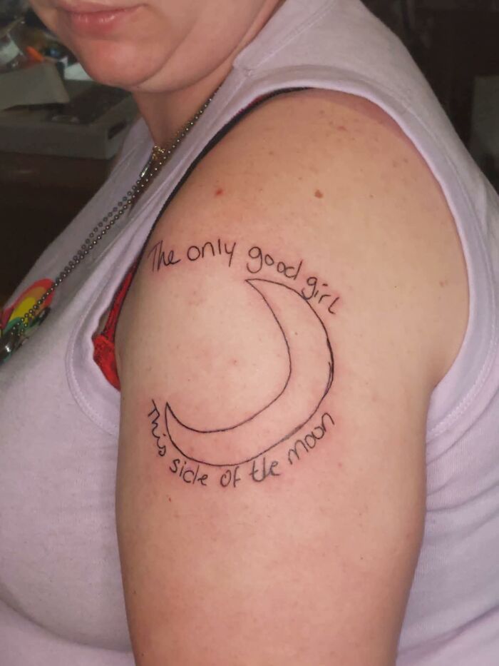 Person showing a hilariously bad tattoo of a crescent moon with misspelled text on their upper arm.