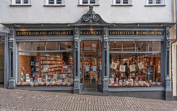 Historic bookstore exterior with large windows displaying books inside, showcasing stunning and impressive bookstores.