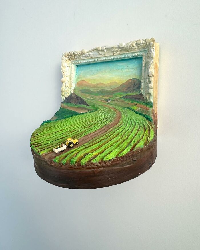 Three-dimensional nature scene blending painting and sculpture with green fields and a toy tractor by a Brooklyn artist.