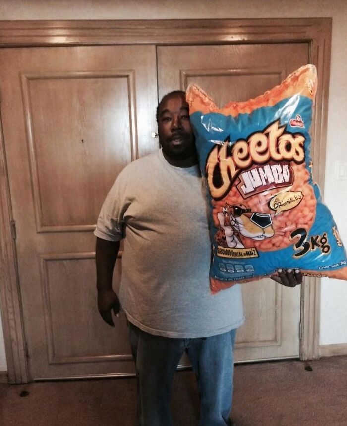Hombre sosteniendo una bolsa gigante de Cheetos, imagen maldita que sorprende por su tamaño exagerado y contexto peculiar.