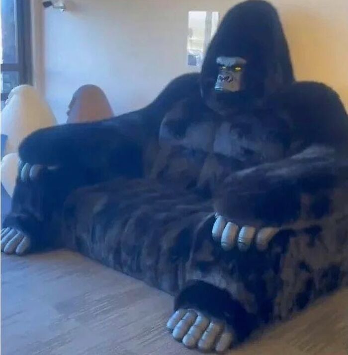 Sofá con diseño de gorila gigante en sala iluminada, imagen maldita que sorprende por su apariencia inusual y creativa.