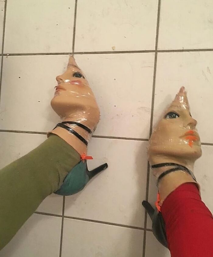 Zapatos con diseño de caras humanas extrañas y malditas vistos desde arriba en un suelo de baldosas.