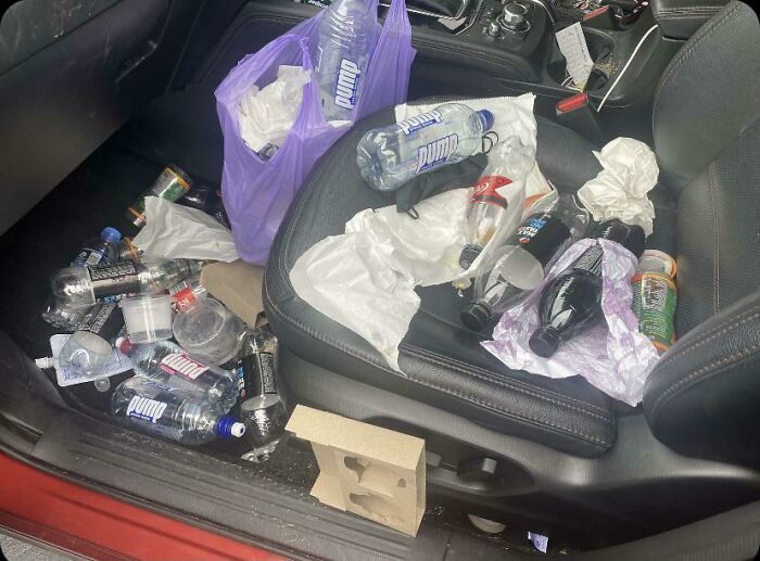 Car interior filled with trash and spilled drinks, showing damage caused by careless use of borrowed items.