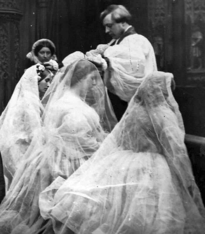 Victorian times wedding ceremony showing brides with veils and a clergyman officiating the ritual indoors.