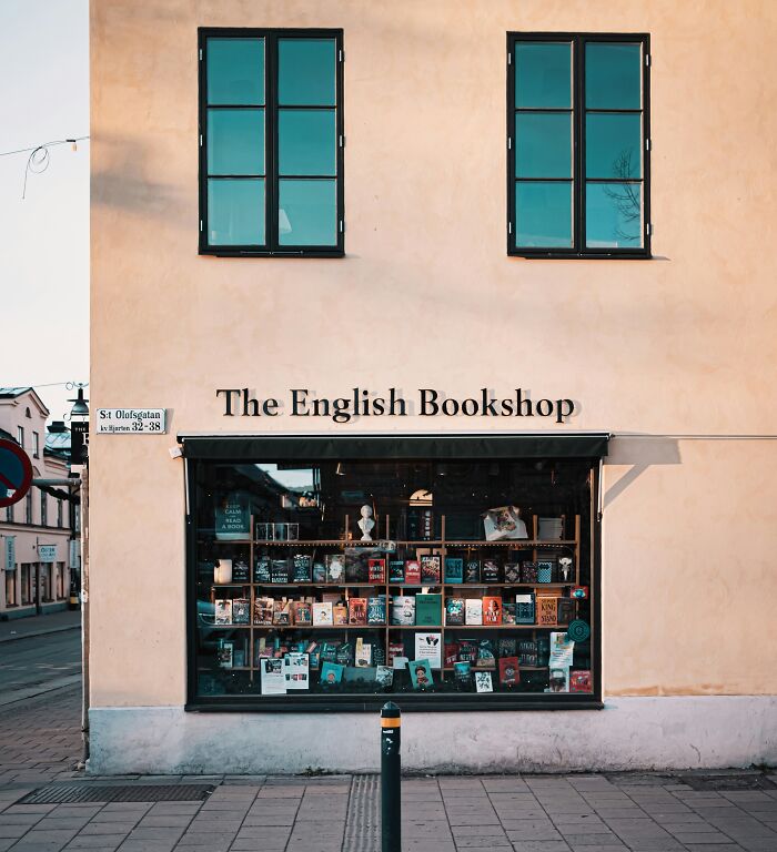The English Bookshop exterior with a large window display showcasing books in a cosy and grandiose bookstore setting.