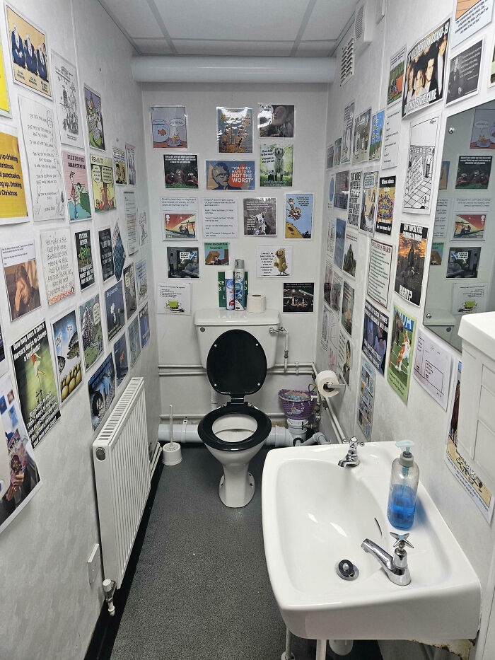 Bathroom with walls covered in humorous posters and quotes showing teachers' love for students and profession.