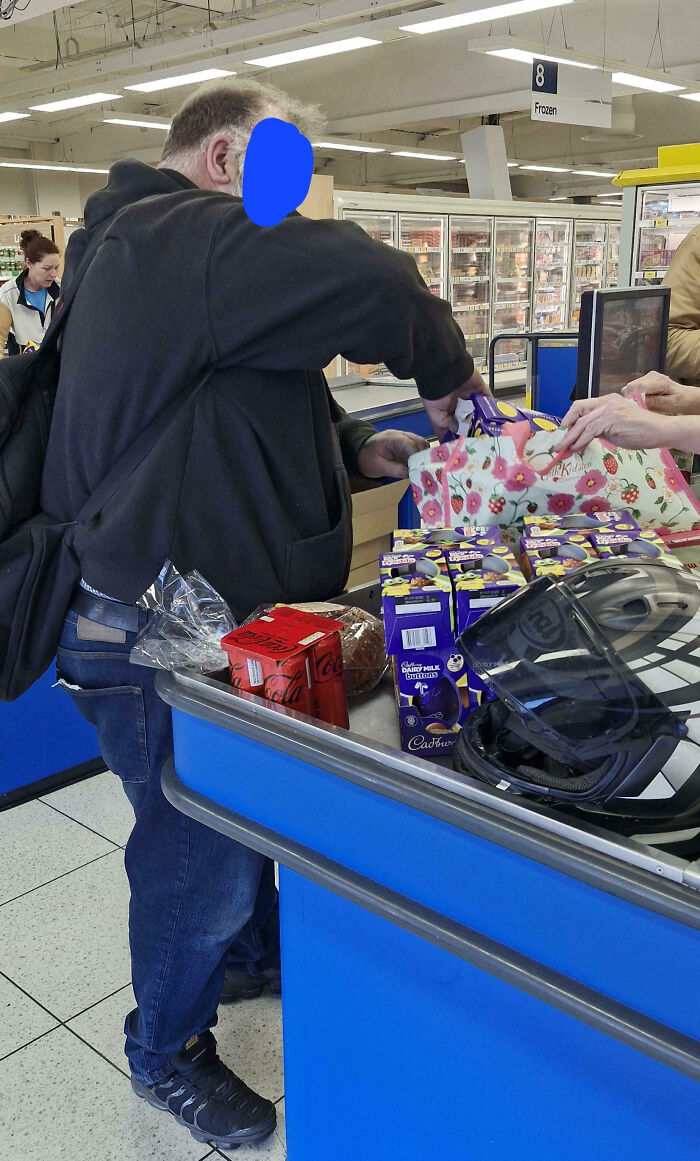 Man at grocery store checkout counter with various items, representing teachers showing love for students and profession.