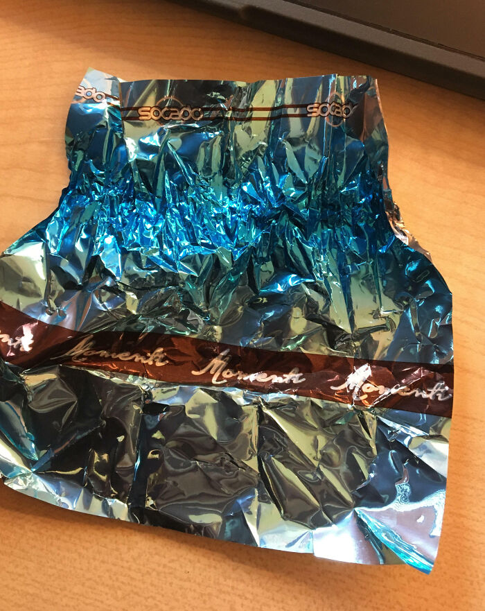 Crumpled blue foil wrapper on wooden surface, highlighting care and appreciation in teacher profession imagery.