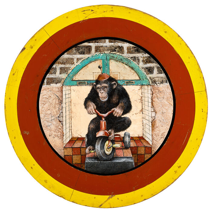 Surreal animal painting of a chimpanzee riding a tricycle inside a colorful circular frame with dreamy storybook style.