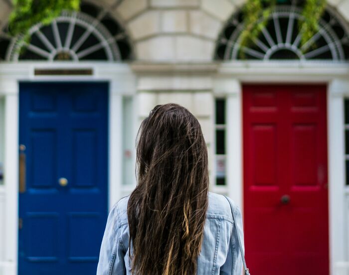 Person with long hair facing two contrasting doors, illustrating the concept of famous paradoxes that confuse even smart people.