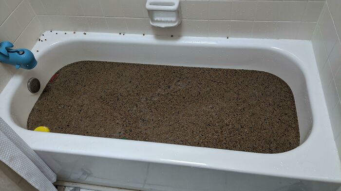 Bañera llena de arena sucia, ejemplo de problemas raros que enfrentan padres y madres en su día a día.
