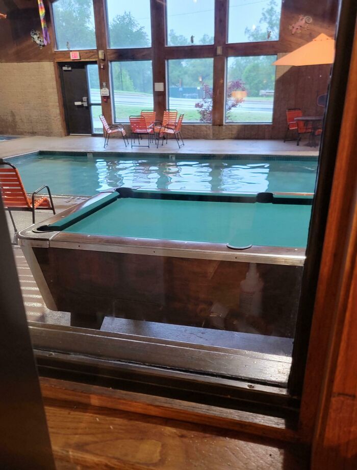 Indoor hotel pool area with seating and a pool table showcasing creative hotel design decisions.