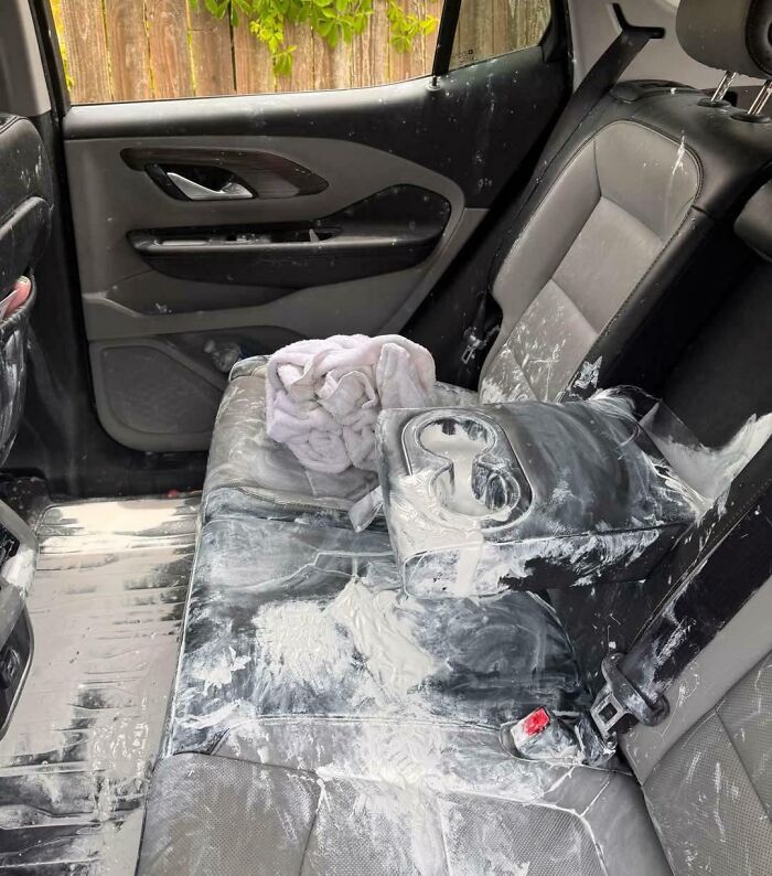 Asiento trasero de auto cubierto de polvo blanco y manchas, ejemplo de padres y madres teniendo un día peor que el tuyo.