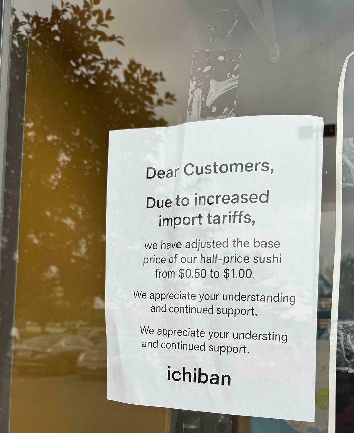 Sign on restaurant window explaining price increase due to import tariffs affecting costs and hitting wallets of Americans.