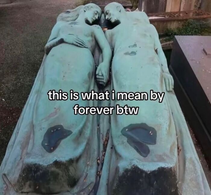 Bronze statues of a couple lying side by side, holding hands, representing cute and wholesome love forever.