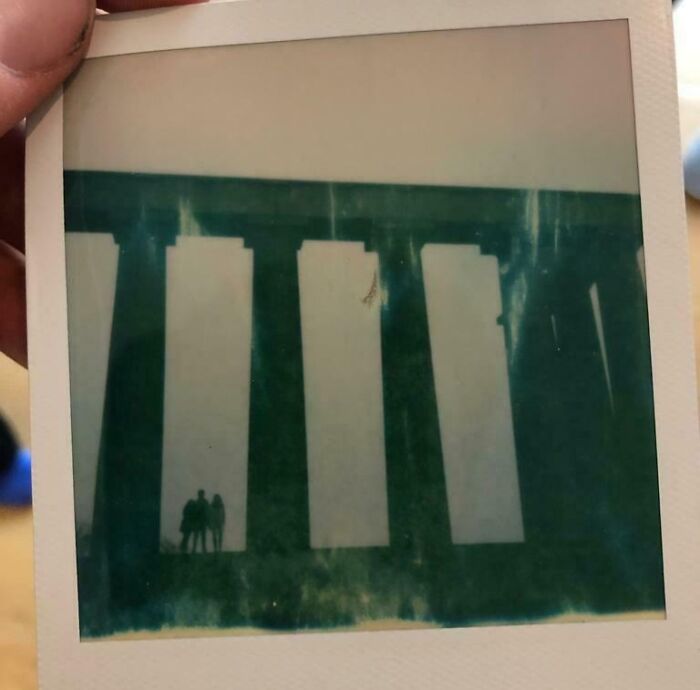 Faded vintage photo showing ghostly silhouettes under large pillars, evoking chilling ghost encounters and eerie atmosphere.