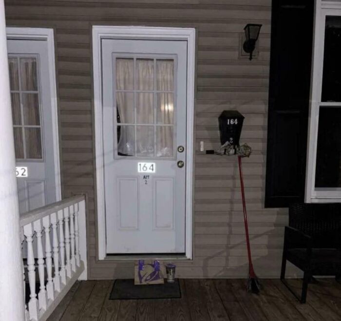 Front door of a house at night with a mailbox and broom, evoking eerie ghost encounters outside the home.