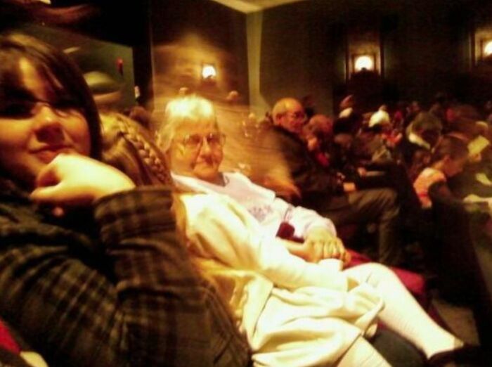 Blurry ghostly figure appearing behind seated people in a dimly lit room suggesting chilling ghost encounters.