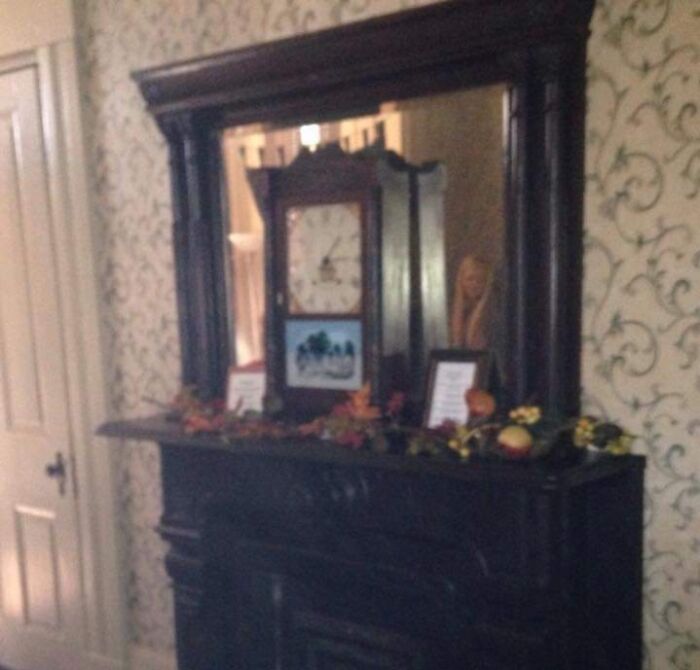 Victorian-style room with an old mantel clock and mirror, evoking a chilling ghost encounters atmosphere.