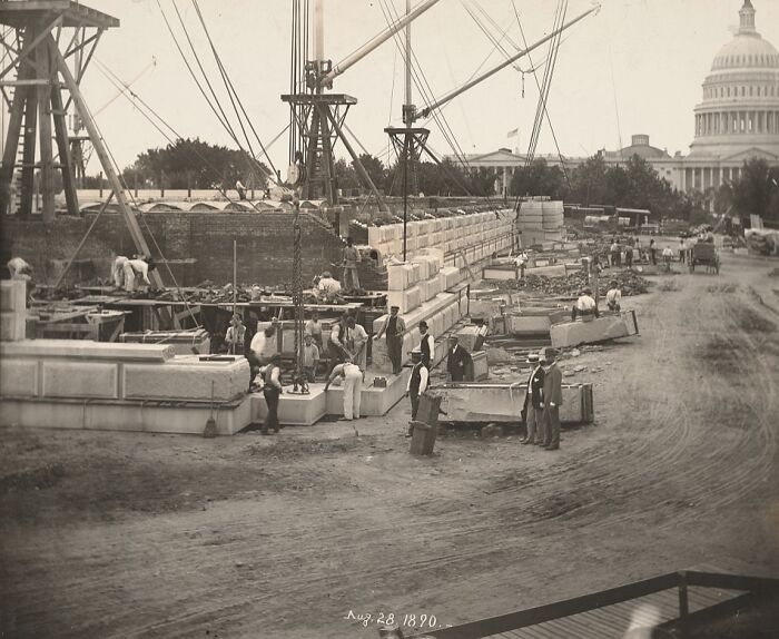 Vintage photo of American working class men constructing a large stone structure near the US Capitol building in 1890.