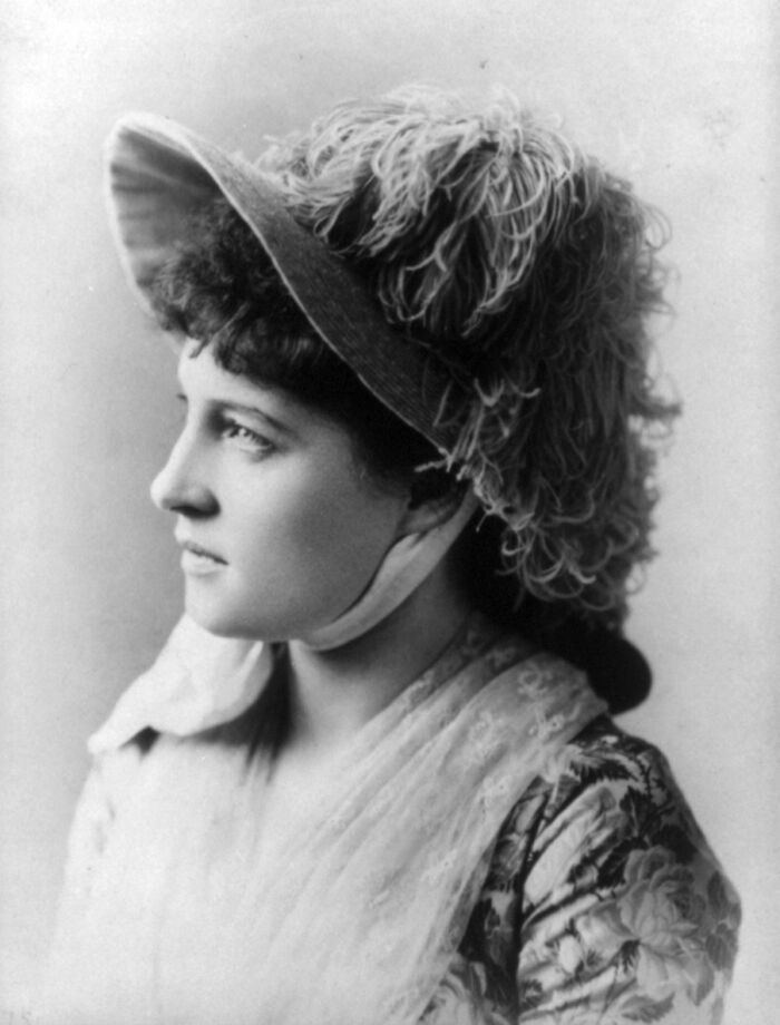 Profile of a famous historical woman wearing a feathered hat and vintage clothing, showcasing good looking famous names from history.