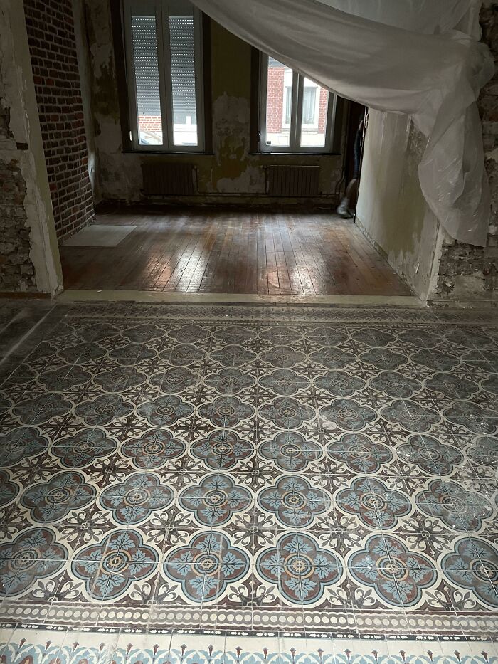 Intricate patterned tile floor uncovered during renovation in old house revealing hidden vintage details.
