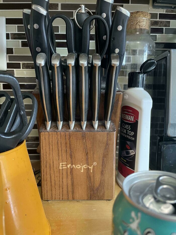 Knife block with six knives of equal size and two scissors creating a funny and utterly confused kitchen scene.