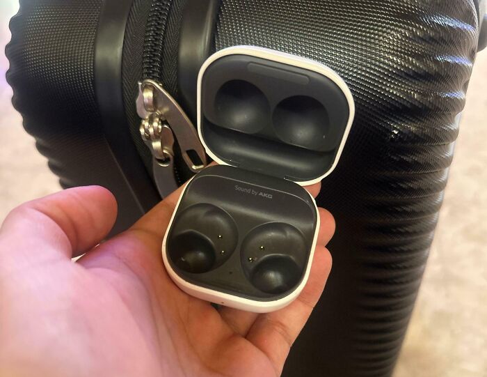 Hand holding a broken AirPods case with missing earbuds, illustrating damage to borrowed electronic items.