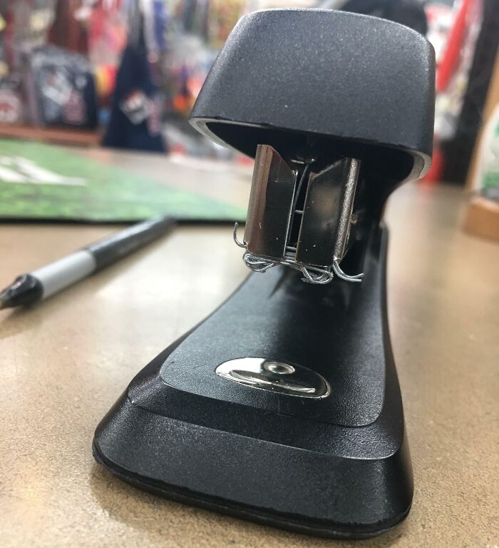 Stapler with damaged and bent metal parts on a desk, illustrating people damaging things they borrowed.